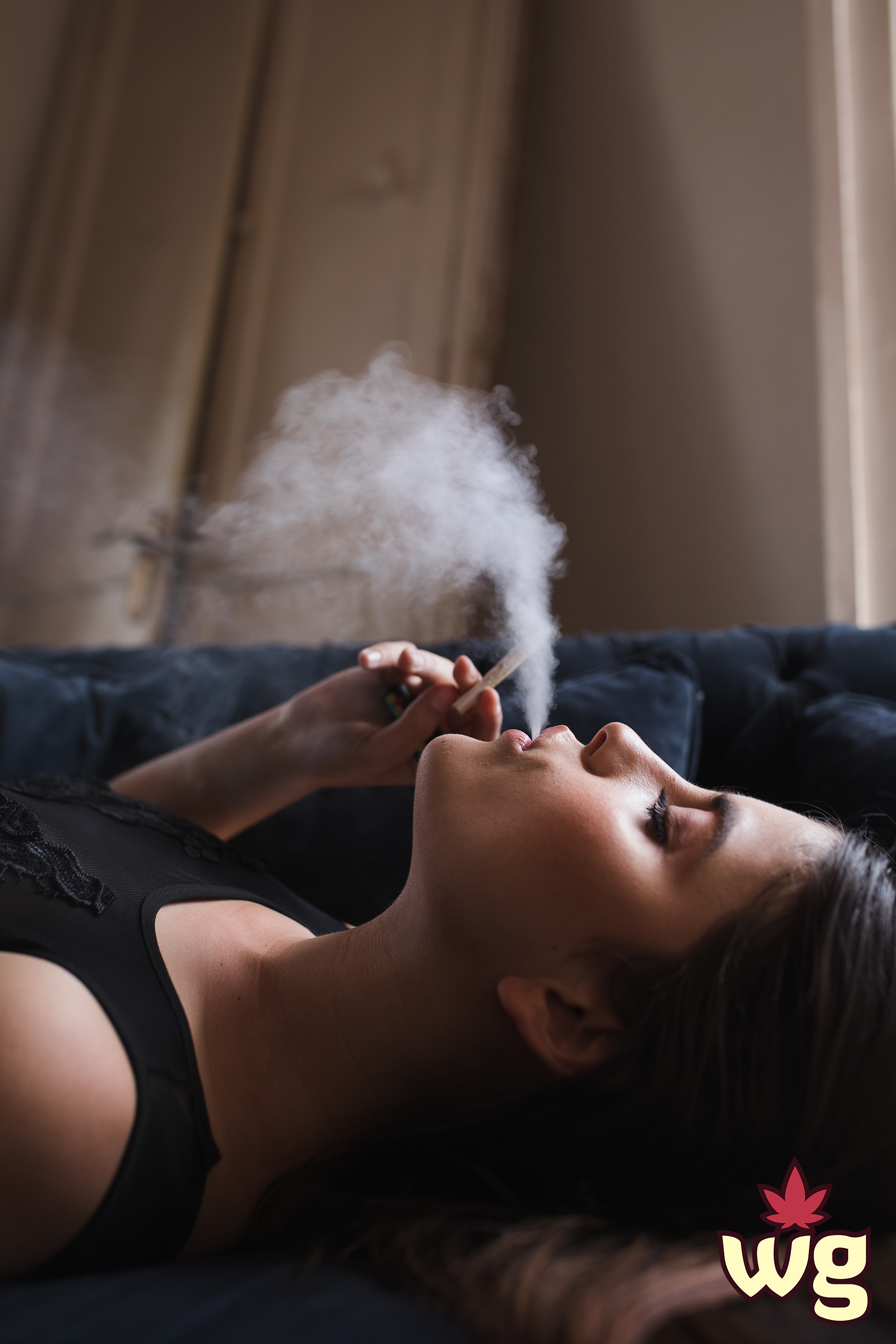 sexy woman getting high on the couch smoking weed